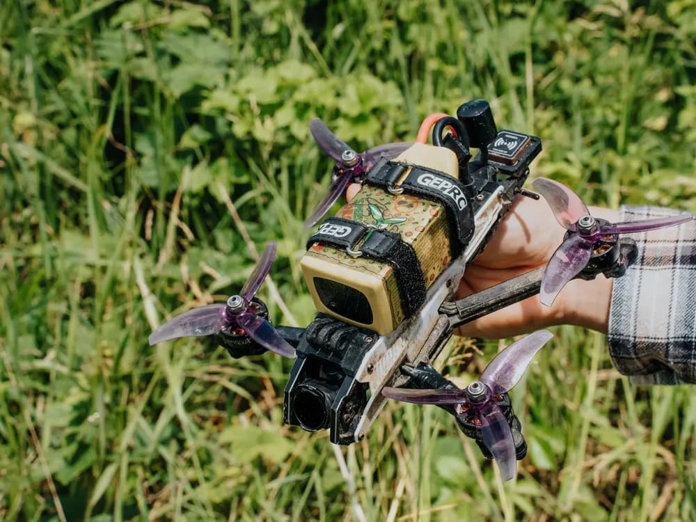 Dron FPV cinewhoop GEPRC trzymany w dłoni w plenerze